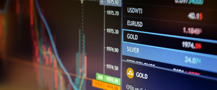 A monitor displaying gold and silver data with candlesticks, emphasizing real-time market information for spot metals.