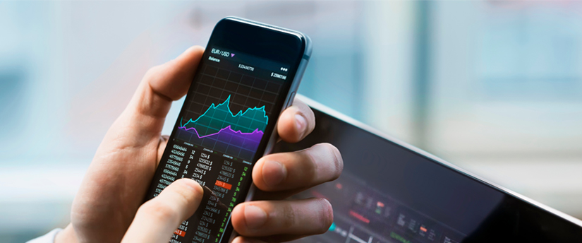A trader with his mobile device, displaying real-time stock market data for analysis.