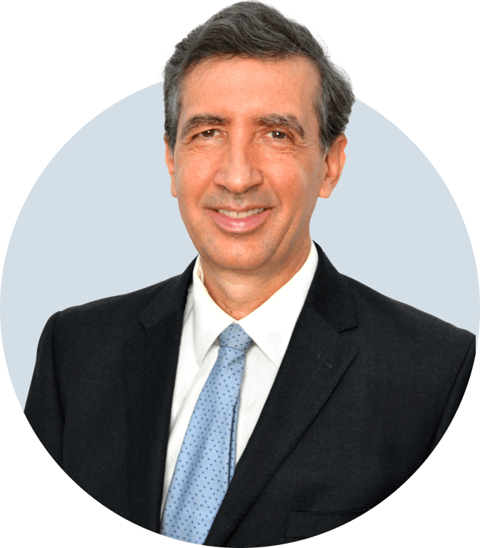 The forex instructor Karl Praz smiling and wearing a black suit with a blue tie