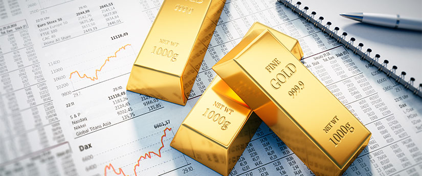 some bars of gold on some pieces of paper with lots of different numbers depicting gold trading online
