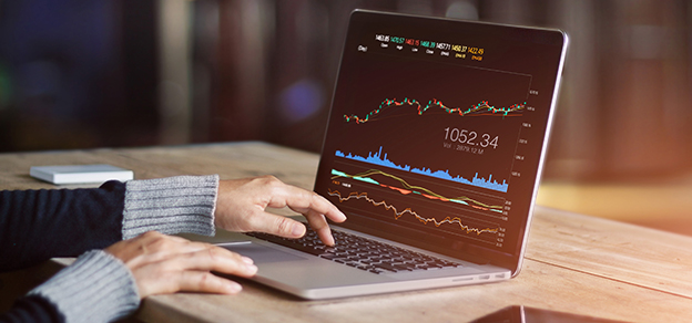 a woman wearing a jumper in front of an open laptop with trade forex ideas and diagrams