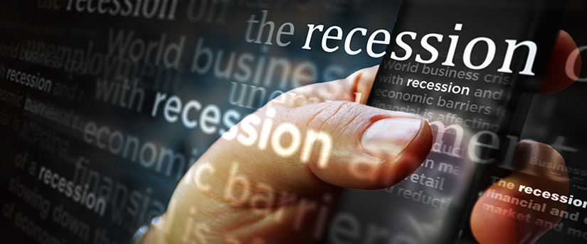 a man’s hand holing a mobile with the words recession, world business crisis and economic barriers.