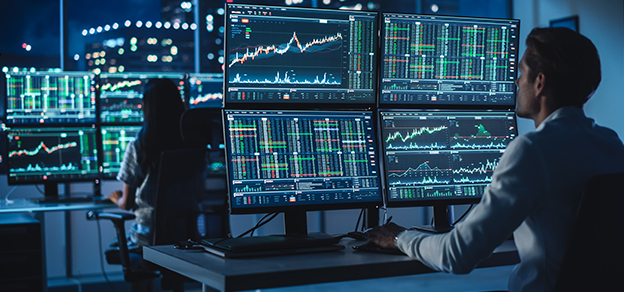 two traders in front of their forex trading monitor setup referring to real forex trading