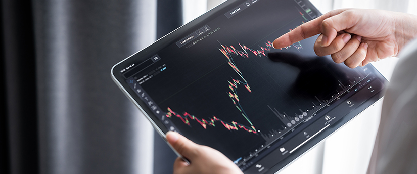 A trader examining their tablet with charts displayed, seeking the best trading platform for their financial endeavors.