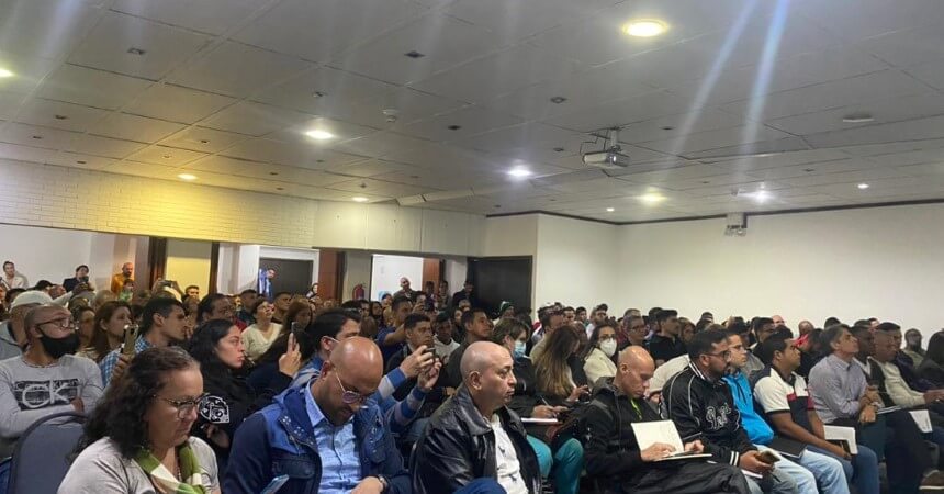 A diverse crowd of individuals seated in a conference room, engaged in a meeting or seminar.