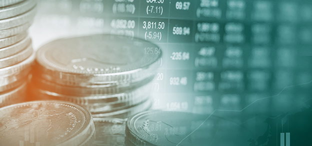 Coins on a table with charts in the backdrop, visually explaining the role of an introducing broker in the financial world.