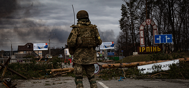 A soldier standing guard on a road in the context of Russia-Ukraine tensions.