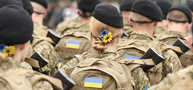 Soldiers marching with the flag of Ukraine, depicting the Russia-Ukraine situation.