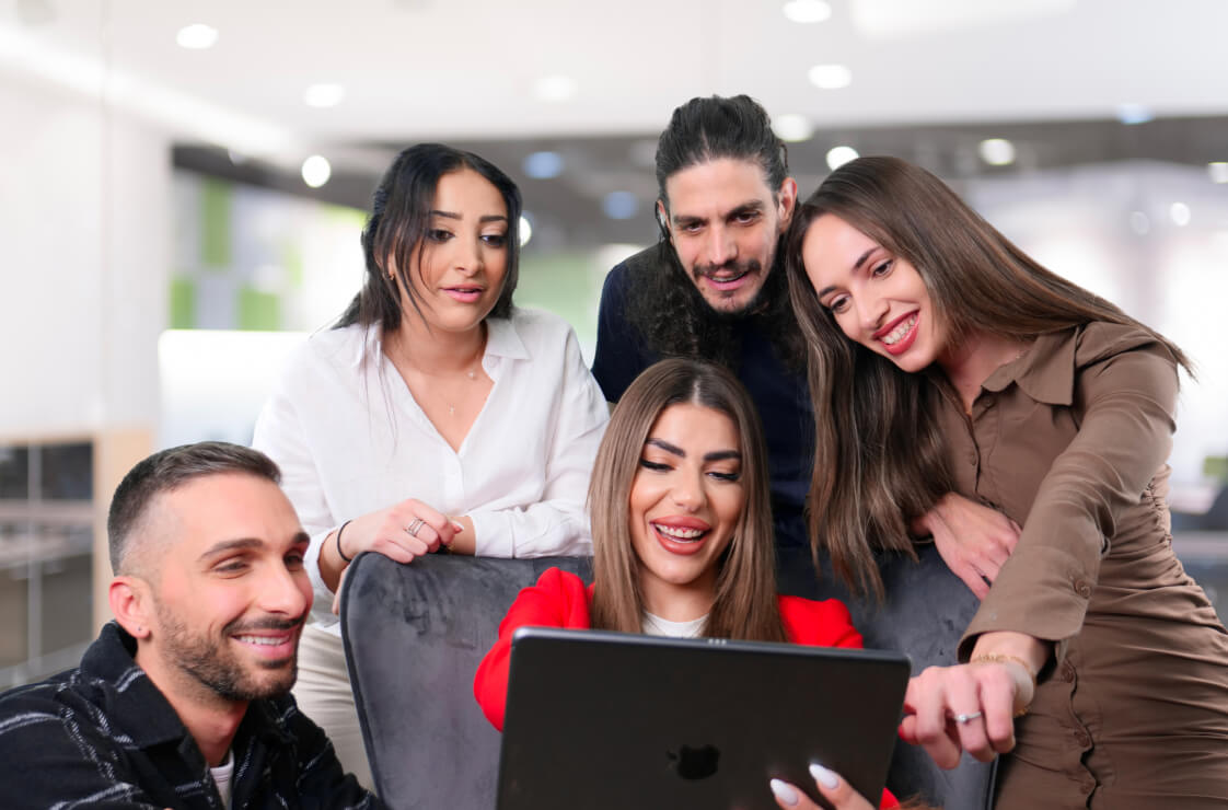 A group of business professionals collaborating on a laptop computer to enhance productivity and teamwork.