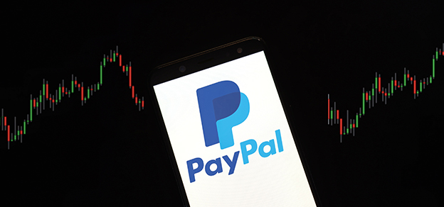A mobile device displaying the PayPal logo with financial charts in the background, blending payment and finance.