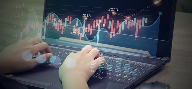 A trader in front of his laptop, analyzing charts, symbolizes the central role of technology in navigating the forex market.