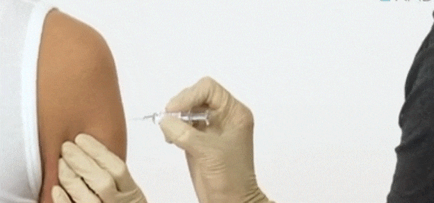 A doctor administering a Pfizer vaccine to a person, symbolizing healthcare and vaccination.