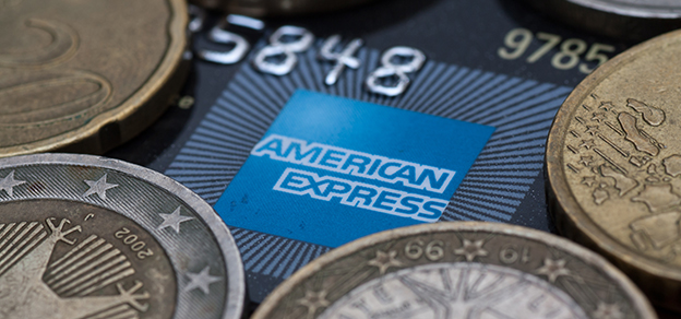 Euros placed on top of an American Express card, illustrating financial transactions and currency exchange with Amex