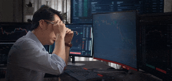 Disappointed trader views forex data on screens, trading forex.