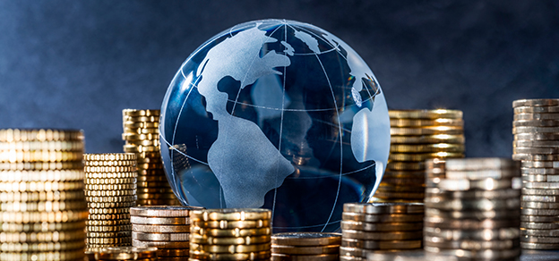 A stack of coins with a globe symbolizing the interconnectedness of the global economy.