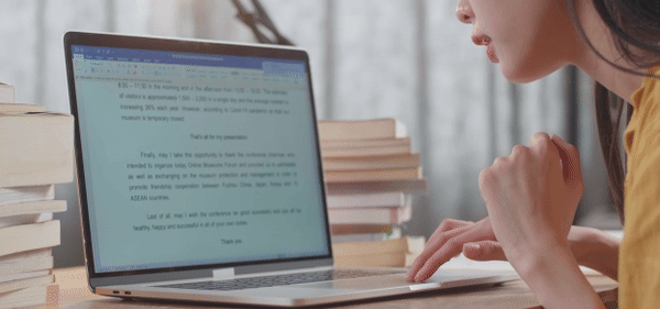 a woman writing on her laptop on Microsoft word.