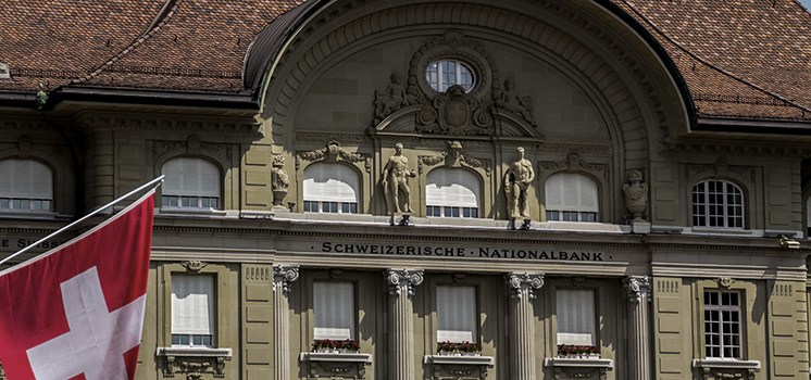 The grand edifice of the Swiss National Bank stands tall, with the national flag fluttering beside it, a symbol of financial prowess and national pride.