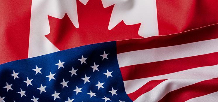 The American and Canadian flags, together, signify the USD/CAD currency pair, where two North American nations' economies converge.