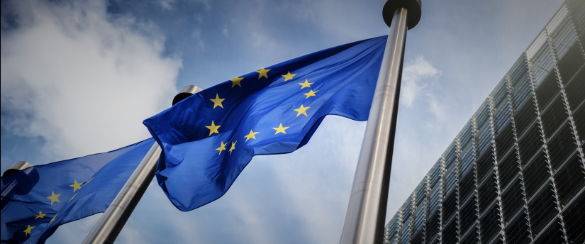 Two EU flags in front of a building, symbolizing the European Central Bank (ECB) and its role in the European Union.