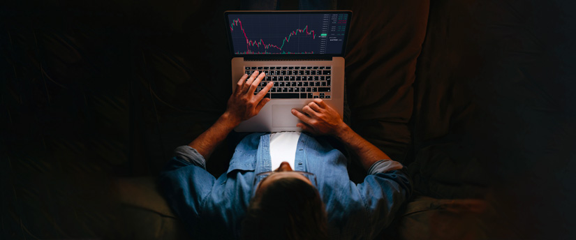 A forex trader, holding a laptop displaying data, emphasizes the role of forex spread in making informed trading decisions.