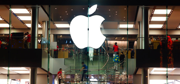 An Apple store with a bustling crowd of buyers and the Apple logo prominently displayed at the entrance.