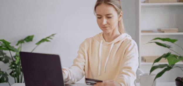 A user in front of her laptop, holding a credit card, emphasizing online shopping through eBay.