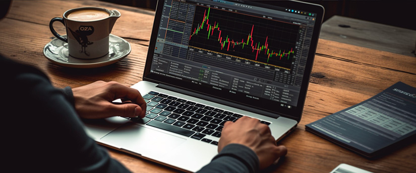 A trader in front of a laptop, focused on analyzing data in the context of CFD trading.