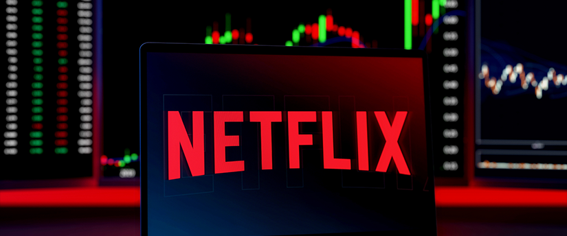A laptop featuring the Netflix logo with candlestick charts in the background, representing the intersection of entertainment and financial data.