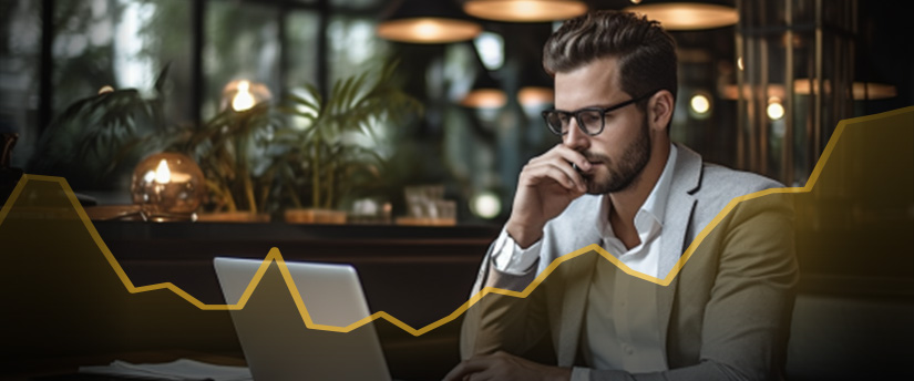 A CFD trader (man) analyzes CFD trading market data on his computer screens, looking for opportunities to invest in contracts for difference.