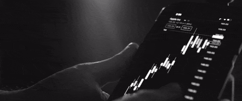 a man holding a phone that shows a candlestick graph, referring to whether CFD is profitable