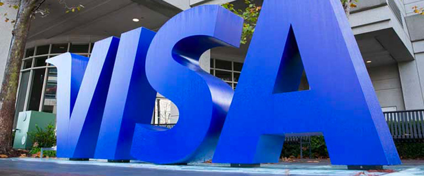 A Visa sign prominently displayed at the entrance of a building, indicating the acceptance of Visa payments.