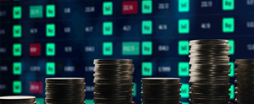 Coins stacked on a table with a stock market graph, depicting cfd trading, coins, and market trends.