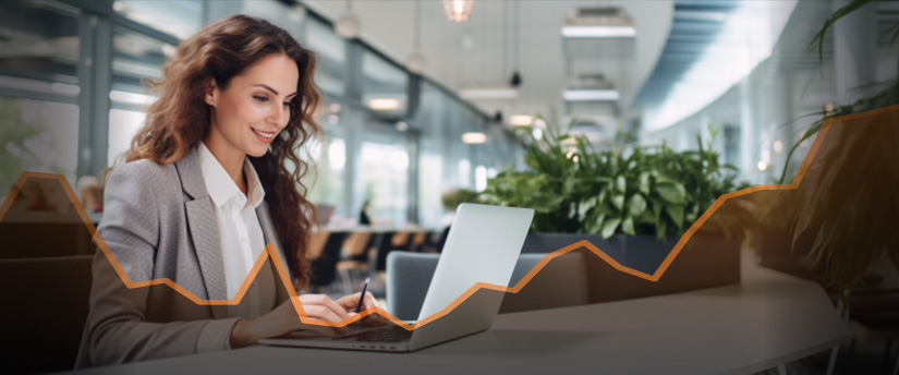 A woman focused on her laptop, analyzing an upward graph. She is engaged in education, forex, and trading.