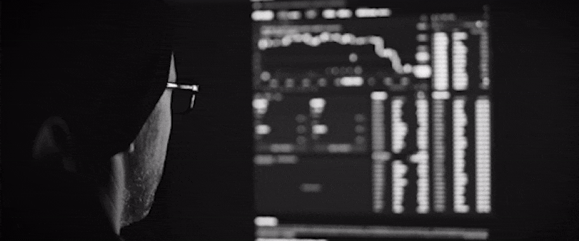 A bespectacled expert intently gazes at a computer screen, possibly analyzing forex trading data during a demo or practice session.