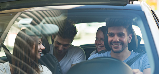 A joyful group of people in a Lyft car, all wearing smiles and radiating happiness.