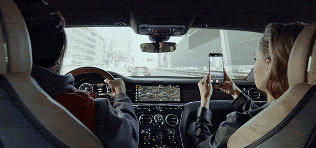 Two passengers in a Lyft car engrossed in their phones, enjoying a comfortable ride