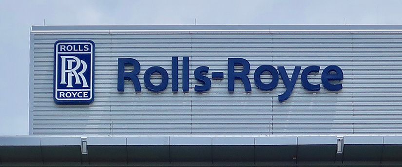 Iconic Rolls-Royce sign adorning a distinguished building, symbolizing luxury and excellence.