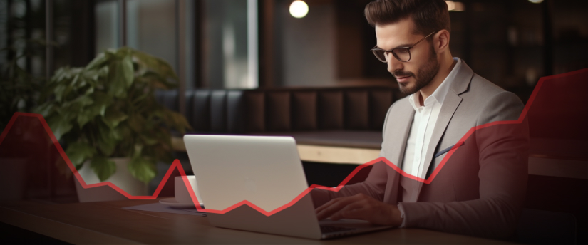 A trader in a suit, intently working on his laptop, engaged in trade without the need for a broker.
