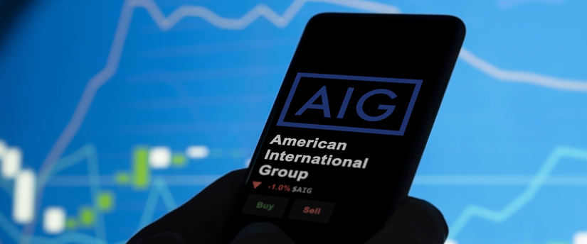 AIG logo on mobile screen with downward arrow graph, symbolizing stock price