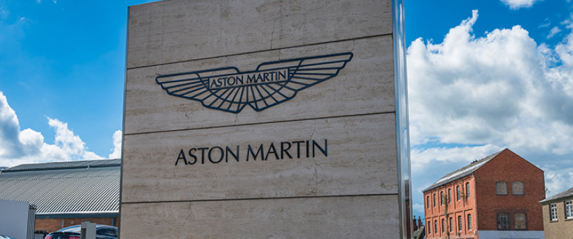 Aston Martin sign in front of a building with the iconic Aston Martin logo.