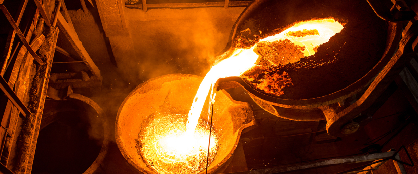 Molten metal being poured into a metal pan at Alcoa