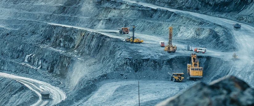 Aerial view of a vast quarry filled with construction equipment and trucks, showcasing the scale of industrial operations.