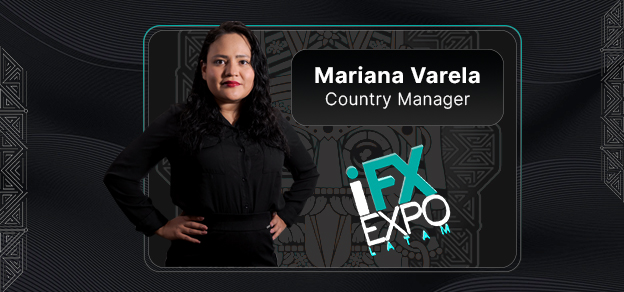 Woman in black shirt and pants standing against black background at traders expo.