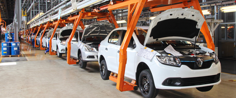 White Renault cars lined up in a factory, ready for production.