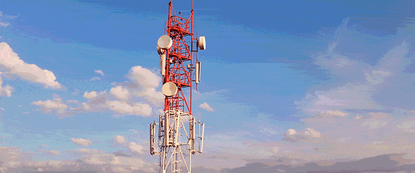 A red and white tower with Verizon antennas.