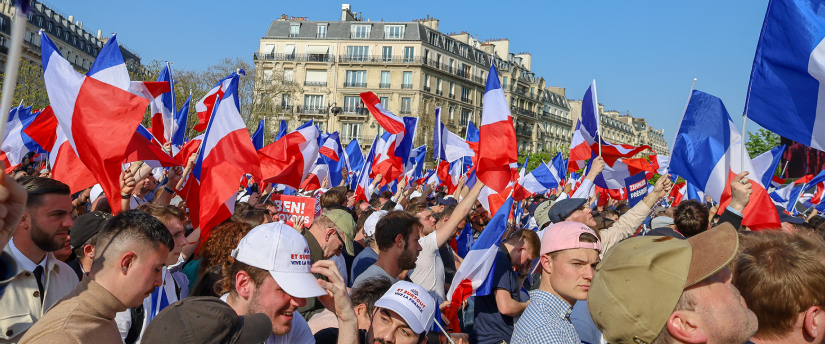 French election supporters holding French flags in a massive crowd