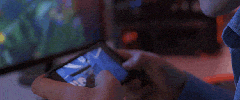 A person focused on playing a video game on a cell phone.