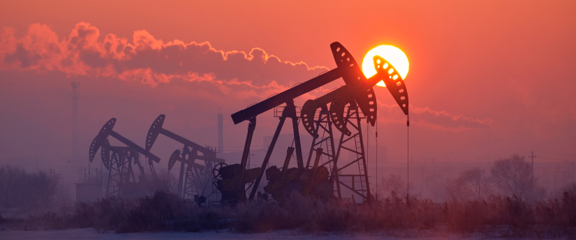 Oil pumps silhouetted against a vibrant sunset, capturing the essence of energy production in a serene landscape.