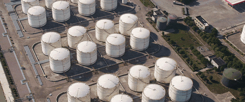 Aerial view showcasing a large industrial storage tank surrounded by a vast landscape, emphasizing its scale and structure.