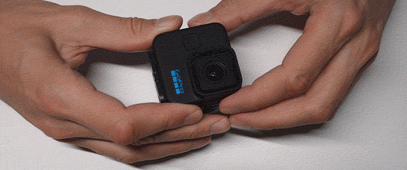 A person is holding a small camera in their hands, ready to capture a moment with focused intent.